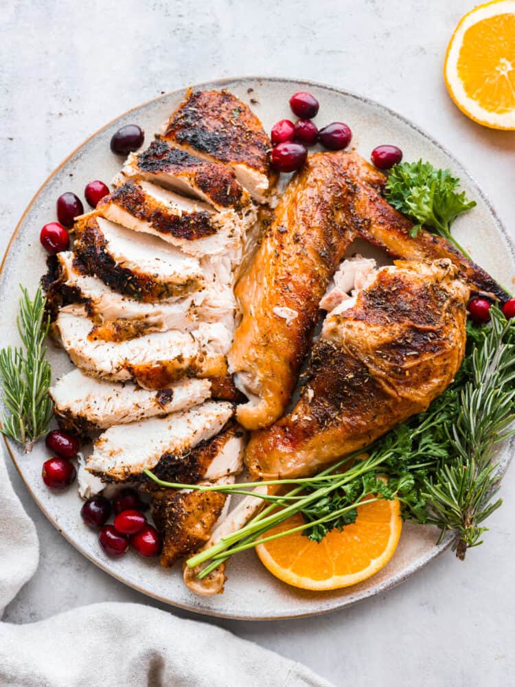 A Spatchcock Turkey cooks faster and more evenly, and will be the most tender and juicy turkey you've ever cooked! Roasted or smoked, this turkey will wow your guests come Thanksgiving day. Turkey cut up and presented on a platter with oranges, cranberries, and fresh herbs.