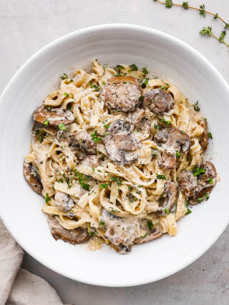 This 15-minute creamy mushroom sauce is so easy to make and packed with rich, savory flavor! Youโre going to love it over pasta and meat dishes! Pasta coated with mushroom sauce, served in a white bowl.