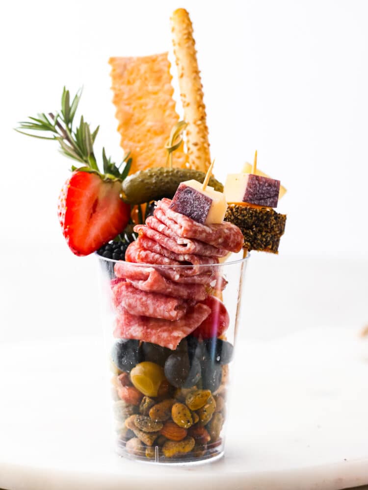 Impress your guests with these quick and easy charcuterie cups! They’re packed with an assortment of meats, cheeses, fruit and nuts; it’s the ultimate finger food! Closeup of a charcuterie cup.