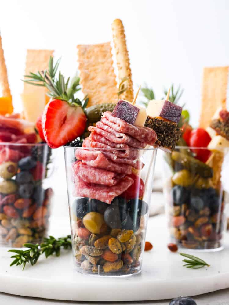 Impress your guests with these quick and easy charcuterie cups! They’re packed with an assortment of meats, cheeses, fruit and nuts; it’s the ultimate finger food! Hero image of multiple charcuterie cups.
