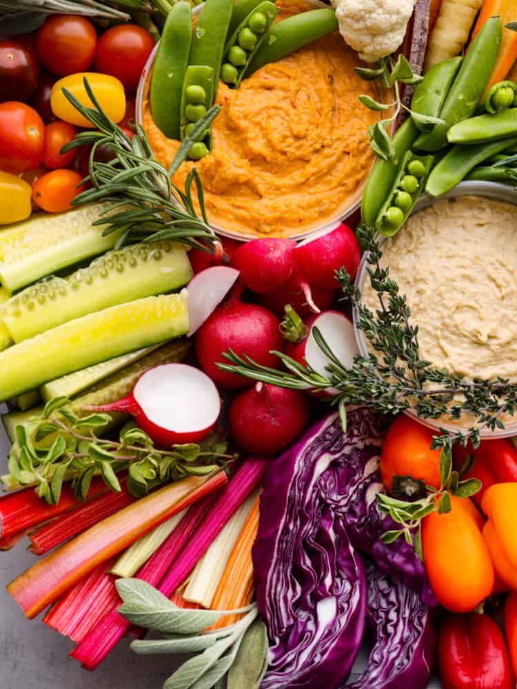 Cruditès is a French dish that is a fresh vegetable board served with delicious dips like hummus. It's the perfect way to add color and variety to your appetizers, and will be the star of your next party! A close up of the tray and all of the veggies and hummus.