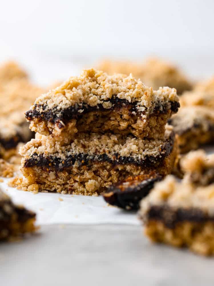 So much better than store bought and so fun to make, these oatmeal fig bars are sweet and salty and everything you hope they would be! The sticky fig jam is sandwiched between two delicious layers of oatmeal crumble and crust. You really can't beat this sweet treat! Fig bars stacked on top of each other and the top one has a bite taken out of it.