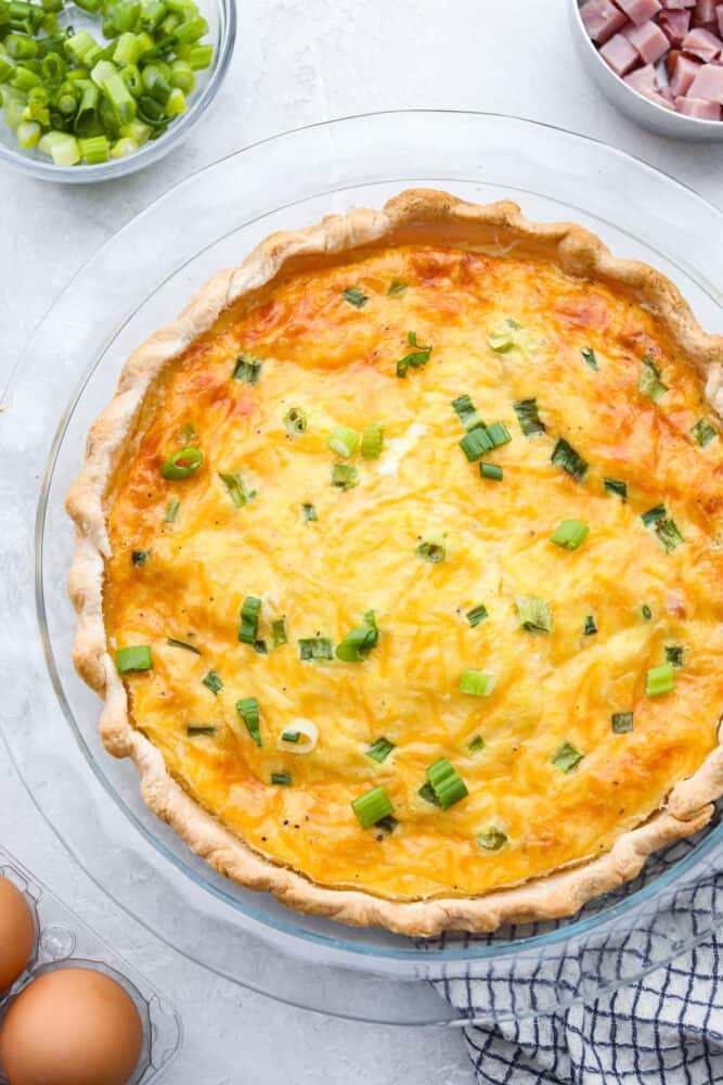 Ham and Cheese Quiche is a classic combination that is sure to make this quiche a new family favorite! Easy to put together, this dish is perfect for brunch, breakfast, or even dinner! The top view of a ham and cheese quiche in the pan.