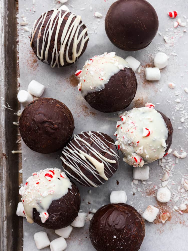 Once you try making hot chocolate with hot chocolate bombs, you’ll never go back. Your hot chocolate will turn out creamy, rich, and packed with deep chocolatey flavor every time! These are great for gift-giving or enjoying on a chilly evening with the family. Top-down view of hot cocoa bombs laid out on a baking sheet lined with parchment paper.