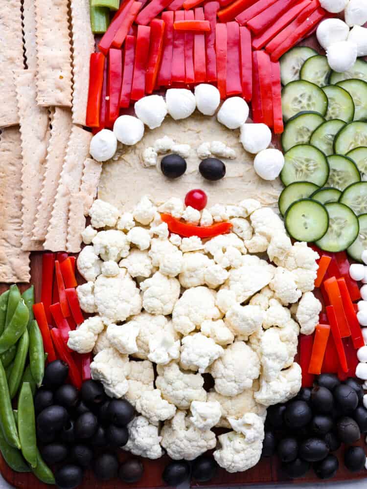 Skip the store-bought platters and make this Santa veggie tray instead! It's a healthy and delicious way to add a little extra holiday cheer to all of your Christmas get-togethers. Closeup of Santa veggie tray.