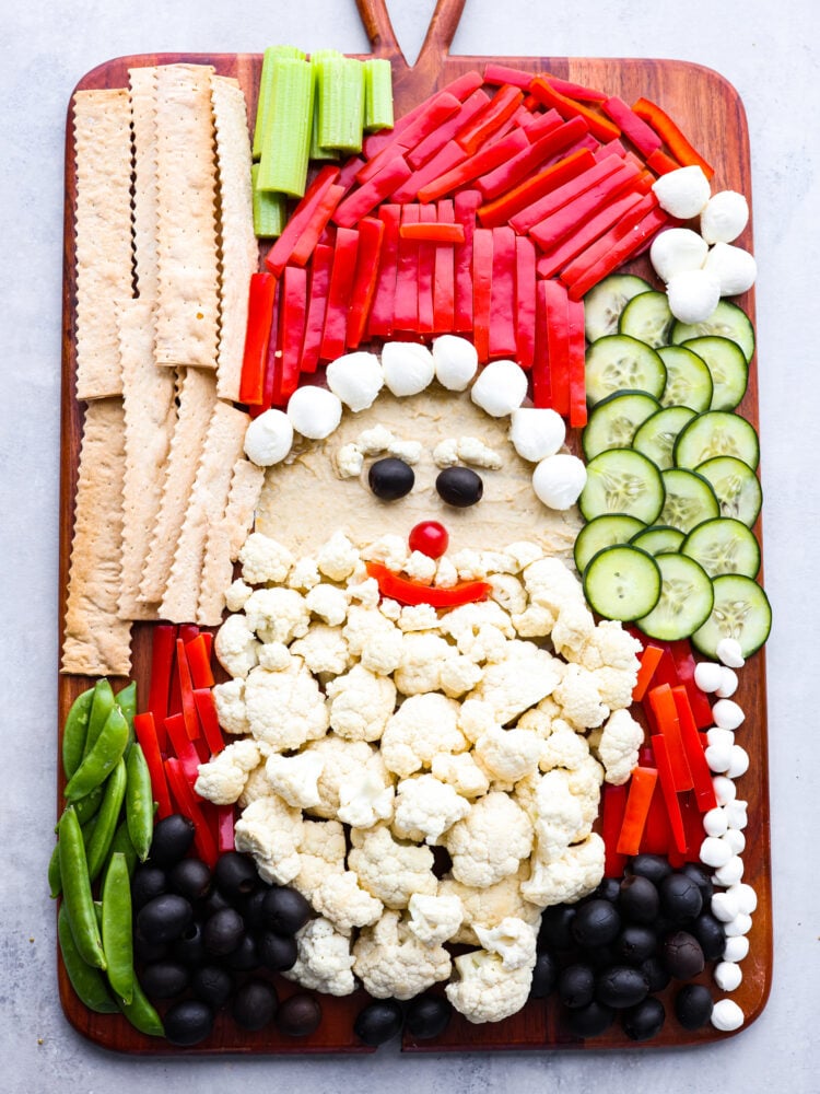 Skip the store-bought platters and make this Santa veggie tray instead! It's a healthy and delicious way to add a little extra holiday cheer to all of your Christmas get-togethers. Top-down view of a complete Santa veggie tray.