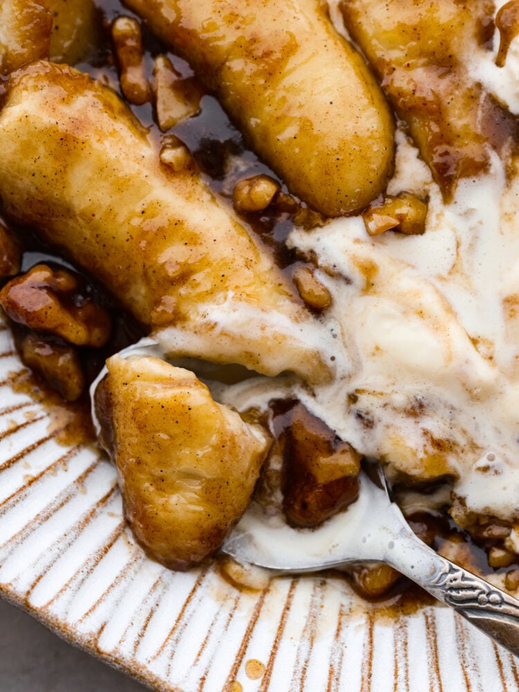 Warm, soft bananas covered in a buttery, cinnamon rum sauce and served with vanilla ice cream. What could be better than that? Bananas foster is a classic dessert that's ready in 15 minutes and sure to impress. Closeup of a bite of bananas foster.