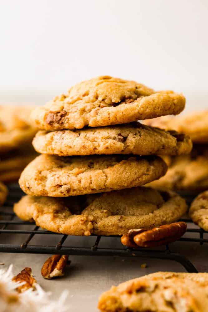 Soft, chewy,ย butter pecan cookiesย made with lightly toasted pecans andย crunchy toffee bits. These are buttery and delicious and there's no mixer or chilling required! 4 butter pecan cookies stacked on top of each other.