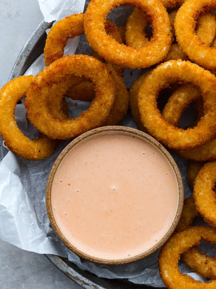The name says it all because this comeback sauce keeps you coming back for more again and again! Itโs tangy, creamy, savory, and is perfect for using as a dip or a spread. Top-down view of comeback sauce served with onion rings.