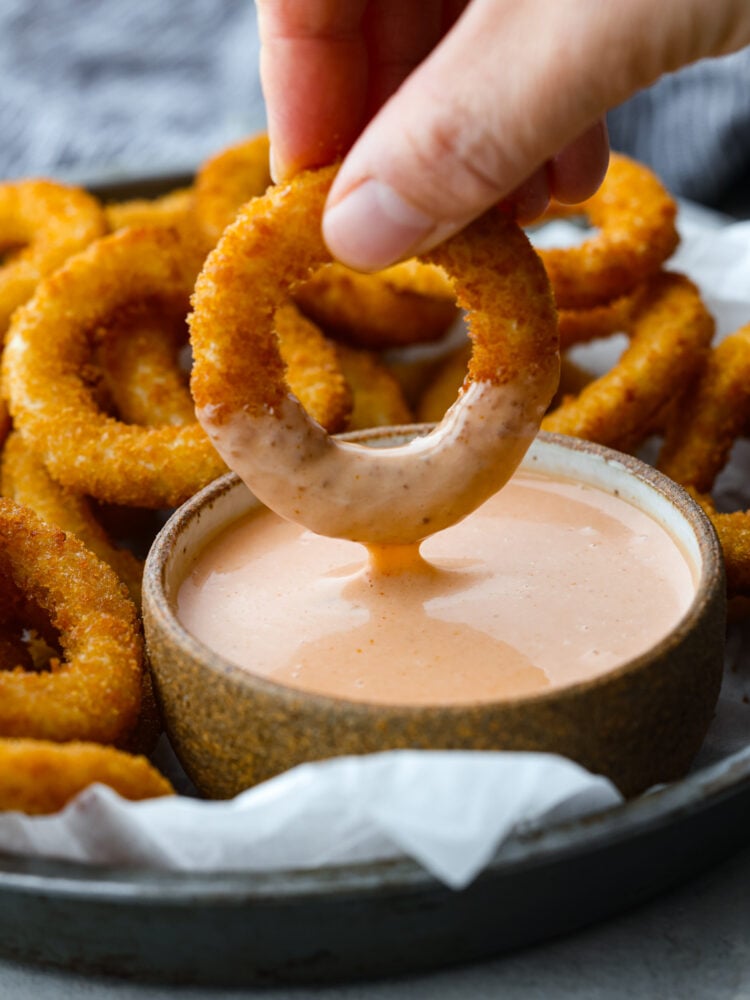 The name says it all because this comeback sauce keeps you coming back for more again and again! Itโs tangy, creamy, savory, and is perfect for using as a dip or a spread. An onion ring being dipped in sauce.