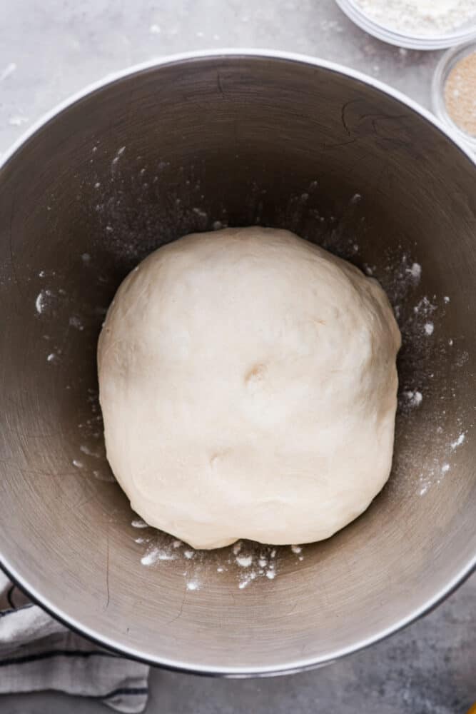 Pillowy soft, with the perfect taste and texture, this quick and easy pizza dough is going to be your go-to recipe for everything! You are going to want to keep this in the archives and use it over and over again. Pizza dough in a metal bowl.