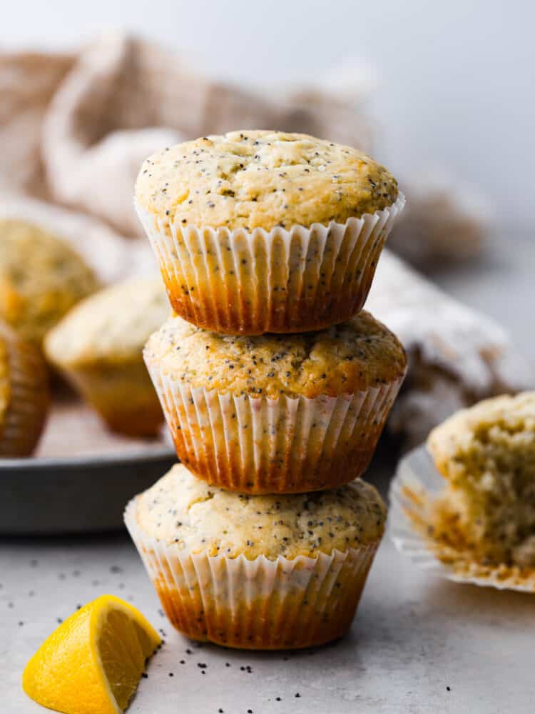These lemon poppyseed muffins are super soft and loaded with fresh lemon flavor thanks to fresh juice and zest. Tender and moist, these muffins are the perfect breakfast or brunch companion! 3 lemon poppy seed muffins stacked on top of each other.