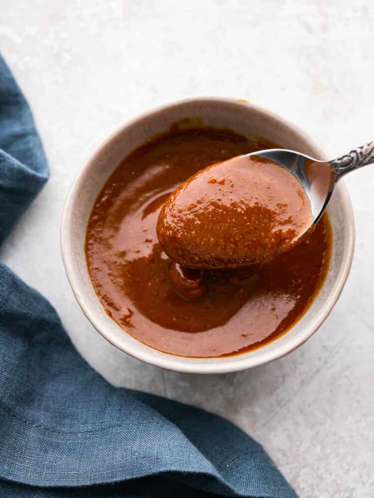 This miso glaze is a great sauce is great for so much more than salmon! It is sweet and savory and packed with umami flavor that goes so great with veggies, fish, and pork belly or a poke bowl. It's a must-have recipe for your recipe book! Miso glaze in a bowl with a spoon taking some out of it.