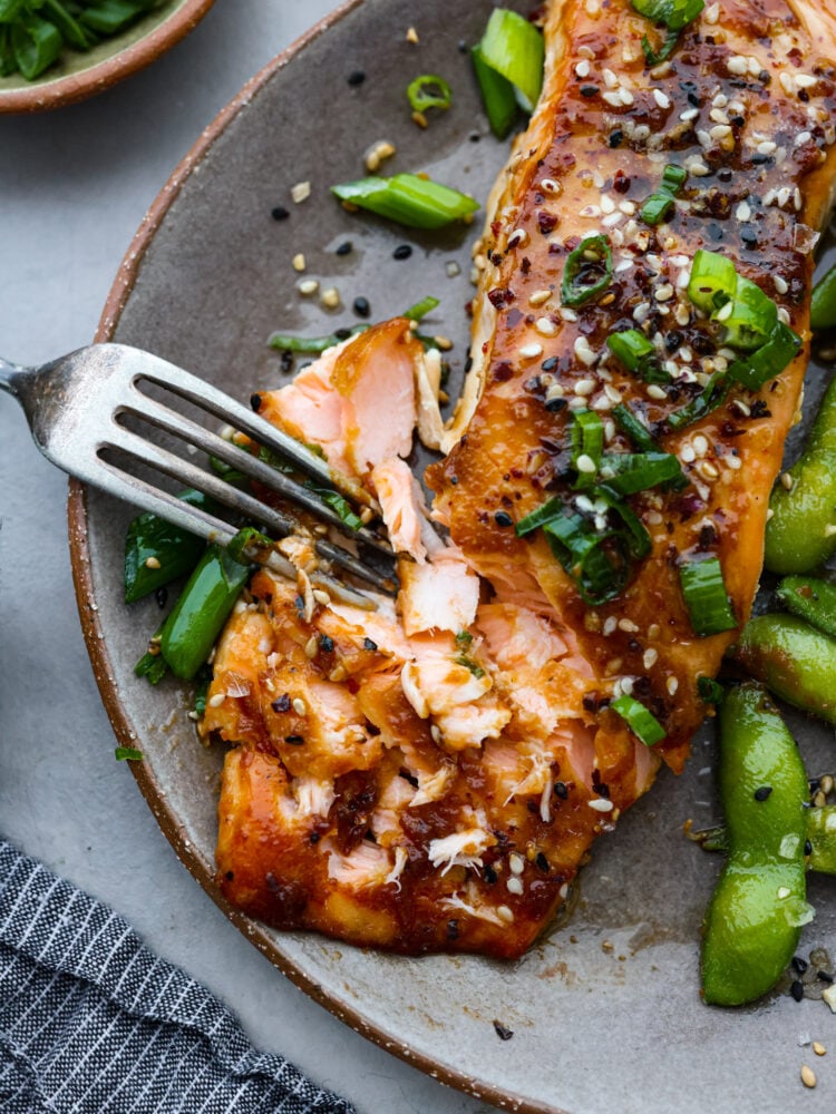 Better than at your favorite restaurant, this miso-glazed salmon is sweet, savory, and full of flavor. It cooks with a delicious caramelized miso glaze on the outside and stays flaky and moist in the middle. You are going to love everything about this recipe! A fork pulling apart flaky miso glazed salmon.