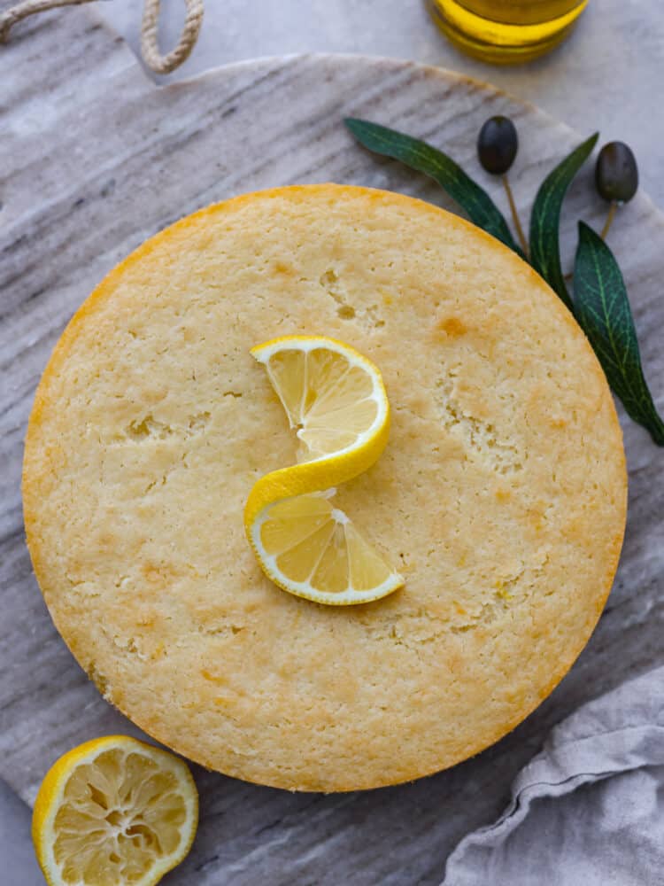 If youโve never tried it, (which you definitely should!) olive oil cake has a light and moist texture, with a slightly crispy crust. The flavor is delicate and subtle, with fruity and nutty notes. You will love every bite! Top-down view of a whole olive oil cake.