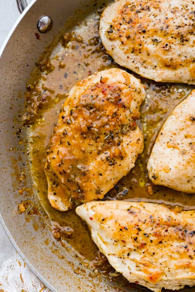 Elevate your chicken breast dinner with this simple and elegant Chicken Pan Sauce. Made with simple ingredients you already have in your kitchen, this sauce takes just 20 minutes to make and will please even the pickiest palates! It's flavorful, juicy, and a must-have in your recipe book. A close up on the chicken in the pan.