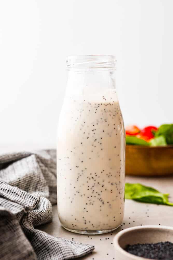 Creamy poppyseed dressing is creamy, sweet, and a little tangy. With just 5 simple ingredients, it's perfect on top of a fresh green salad and is a must-have in your recipe book! Creamy poppyseed dressing in a glass jar.