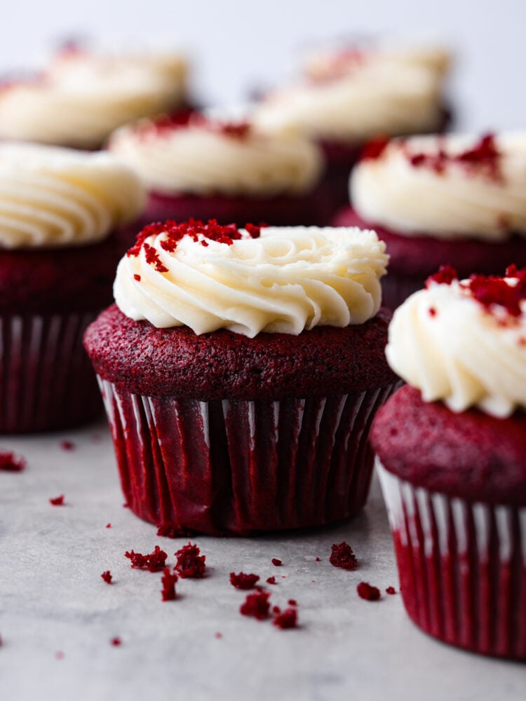 These red velvet cupcakes are perfectly moist cake with the most beautiful and deep red color. They are topped with classic cream cheese frosting, and once you eat one, you will agree that these are the best! Hero image of red velvet cupcakes topped with cream cheese frosting.