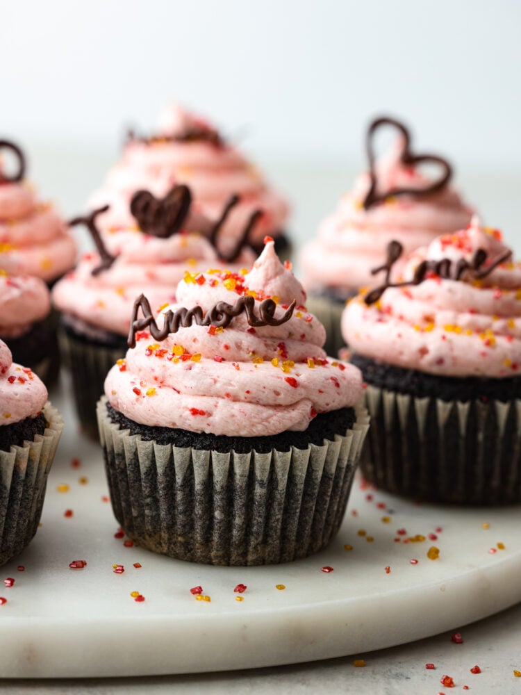 Show your sweetheart how much you care with these decadent chocolate and strawberry Valentine's Day Cupcakes. They are simple to make for parties and gatherings and are always a hit. Valentine's Day Cupcakes with sprinkles and chocolate words like amore and I love you.