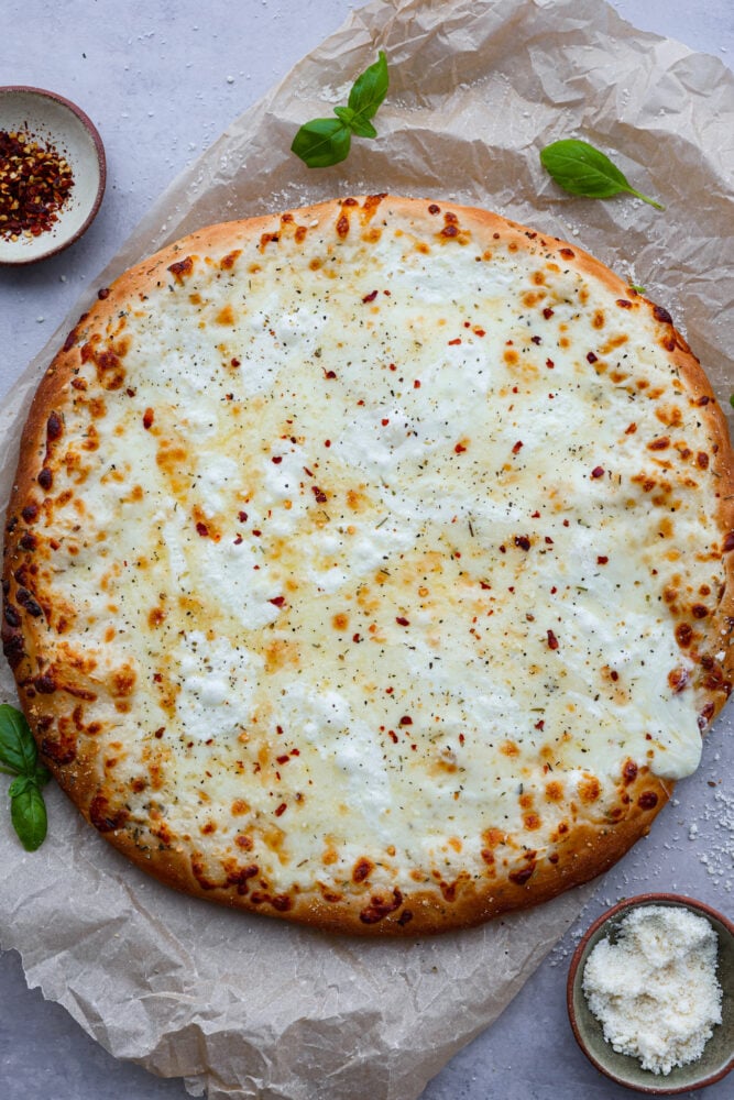 White Pizza, also called pizza bianca, is a delicious and soft and chewy pizza crust topped with a creamy Parmesan sauce and mozzarella cheese. There's every reason to fall in love with this recipe. It's quick and easy and a total hit! A whole white pizza from above.
