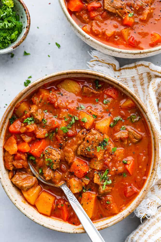 Hungarian goulash is a hearty and scrumptious beef stew that is Hungary's national dish. Beef is slow-cooked with onions, tomatoes, carrots, and potatoes to make this the ultimate comfort food and perfect dish for cold days. Hungarian goulash in a bowl.
