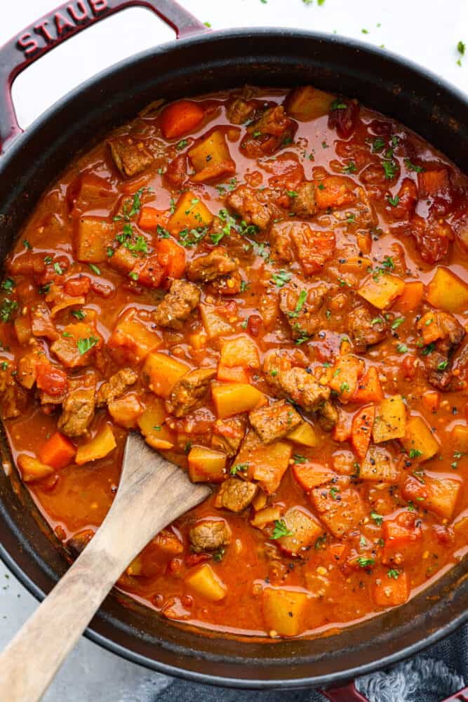Hungarian goulash is a hearty and scrumptious beef stew that is Hungary's national dish. Beef is slow-cooked with onions, tomatoes, carrots, and potatoes to make this the ultimate comfort food and perfect dish for cold days. Hungarian goulash in a pot.