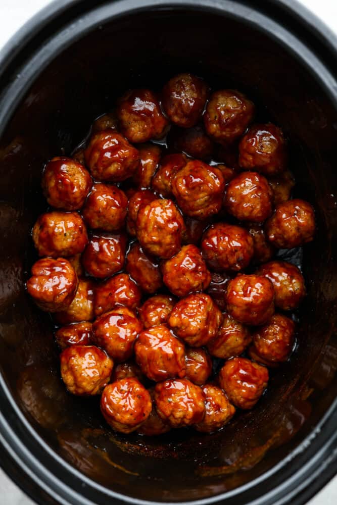 BBQ Meatballs are cooked in a slow cooker and smothered in a delicious barbecue sauce. They are the easiest meatball recipe you'll ever try, and they are perfect for parties and simple appetizers. An overhead look at the bbq meatballs in the crock pot.