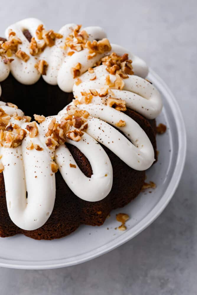 Carrot bundt cake is a beautiful combination of moist and sweet carrot cake, topped with divine cream cheese frosting and chopped walnuts. It's full of warm spices and bright flavors that blend together for the perfect festive dessert. Carrot bundt cake with cream cheese frosting.