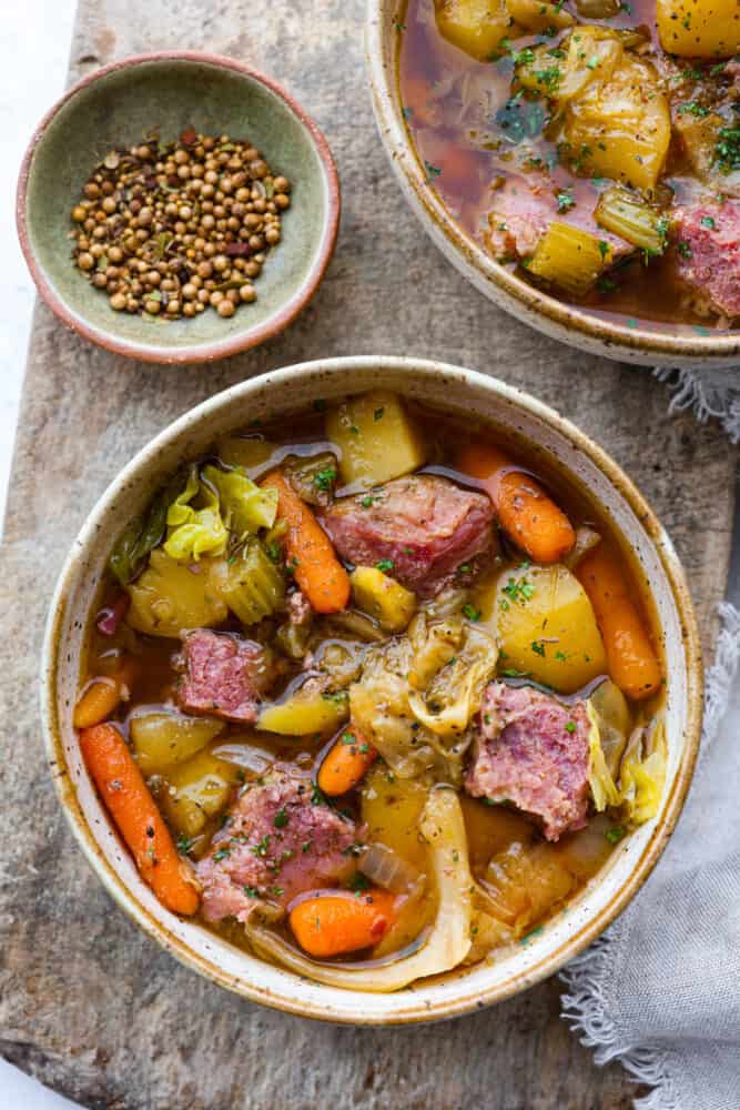 Corned Beef and Cabbage slow cook all day with hearty vegetables making one delicious stew! This is a classic recipe with nostalgic flavors, and it's so easy to whip up. A bowl of slow cooker corned beef and cabbage stew.