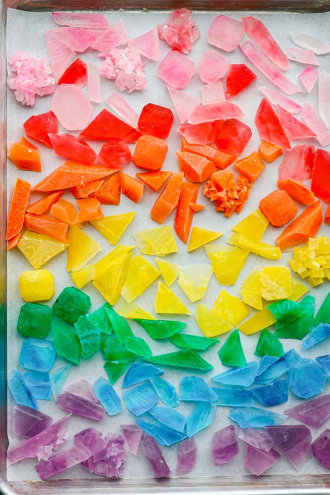 This gorgeous crystal candy tastes as good as it looks! Inspired by the Japanese candy "Kohakutou," it's such a fun treat to make with the kids. It has an addictive crunch to it and can be made with any flavor of your choosing! Top-down view of crystal candy on a baking sheet with parchment paper.