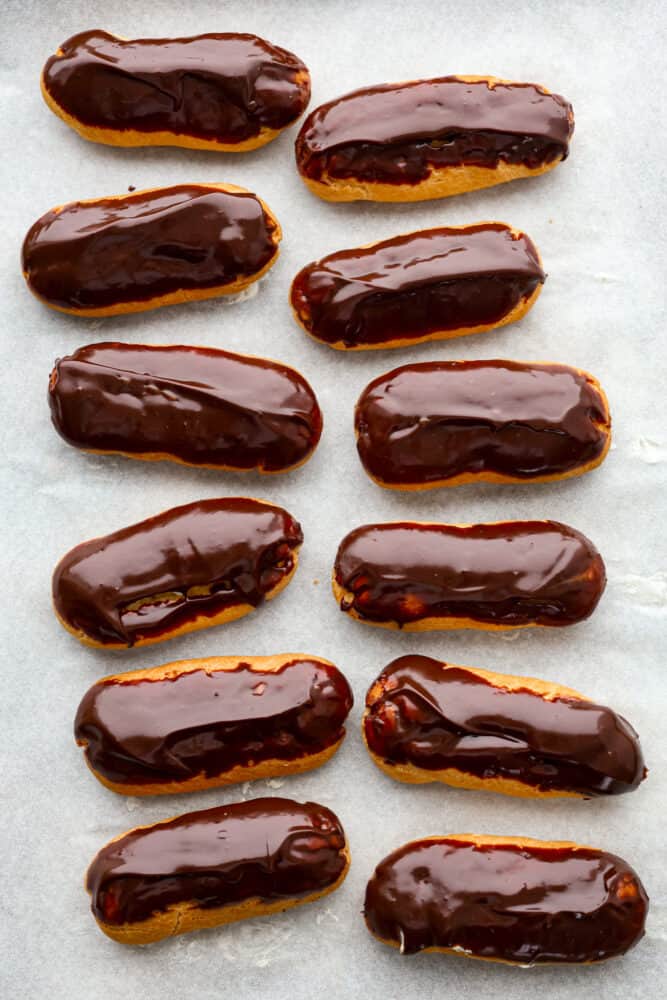 Skip the bakery and make your own delicious eclairs at home! These cream-filled delights are a labor of love and are sure to become one of your new favorite dessert recipes. Top-down view of multiple chocolate dipped eclairs.