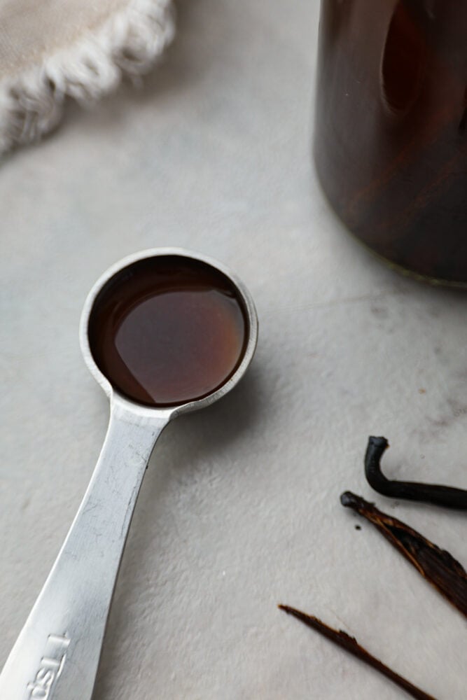 Making your own homemade blend of vanilla extract is quick and easy. Trust me, it will take all of your recipes to the next level! Plus, it only takes 2 simple ingredients to whip up! A measuring spoon filled with vanilla.