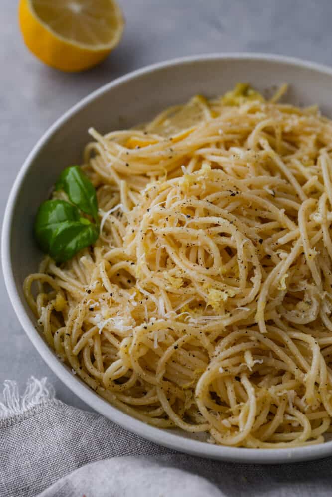 Pasta al limone is a really simple and classic Italian dish of long noodles and a parmesan and lemon topping. It is covered in melted butter and tangy lemon, and is the perfect thing to cook for dinner when you don't know what to make! A close up on pasta al limone.