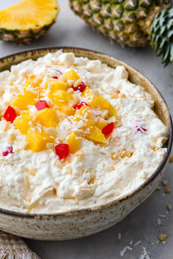 Get ready for this Pineapple Fluff to become your most requested recipe for potlucks! Similar to orange fluff, it's a delicious blend of pineapple chunks, coconut cream, marshmallows, and coconut flakes. It's seriously addicting and so easy to make! Pineapple fluff in a bowl.