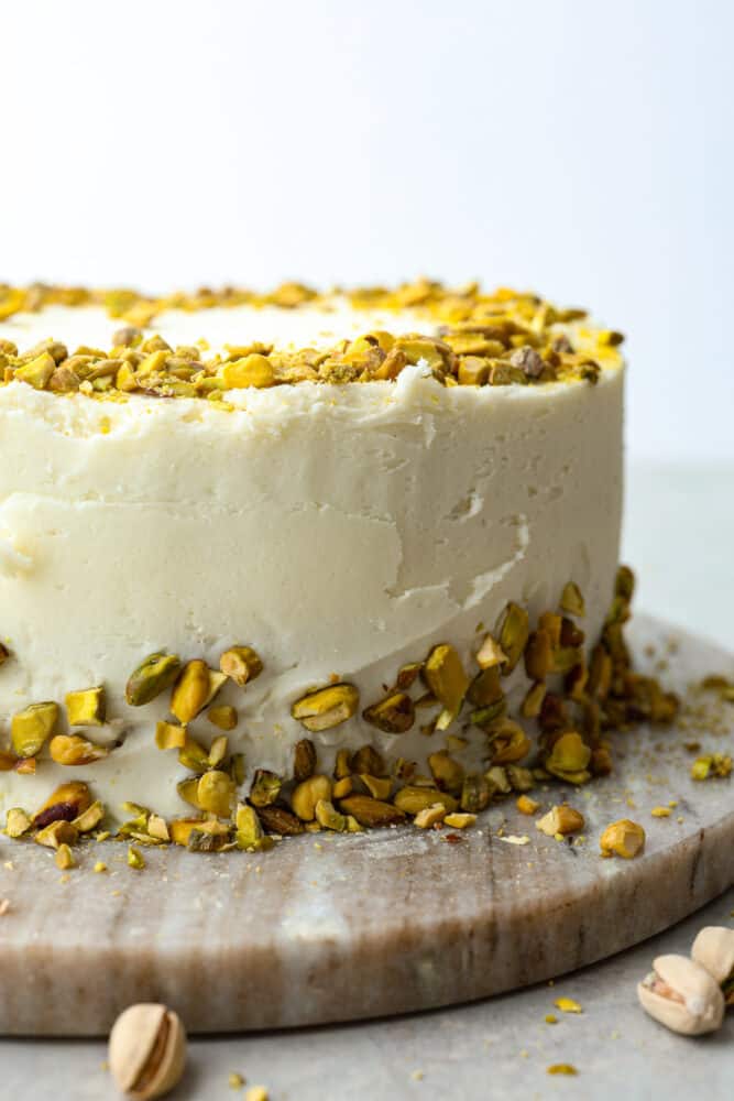 This light and airy Pistachio Cake is made from scratch, full of real pistachios, and topped with a delicious buttercream frosting. It's a classy cake that will impress your guests on any occasion! A whole pistachio cake.