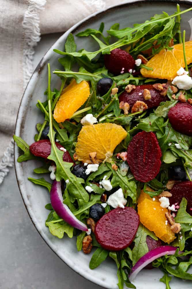 This roasted beet salad will have you singing the praises of this root veggie and begging for seconds! It's tossed with fruit, nuts, and crumbled cheese all coated in a delicious homemade balsamic vinaigrette. A light lunch that's both healthy and delicious! Hero image of roasted beet salad.