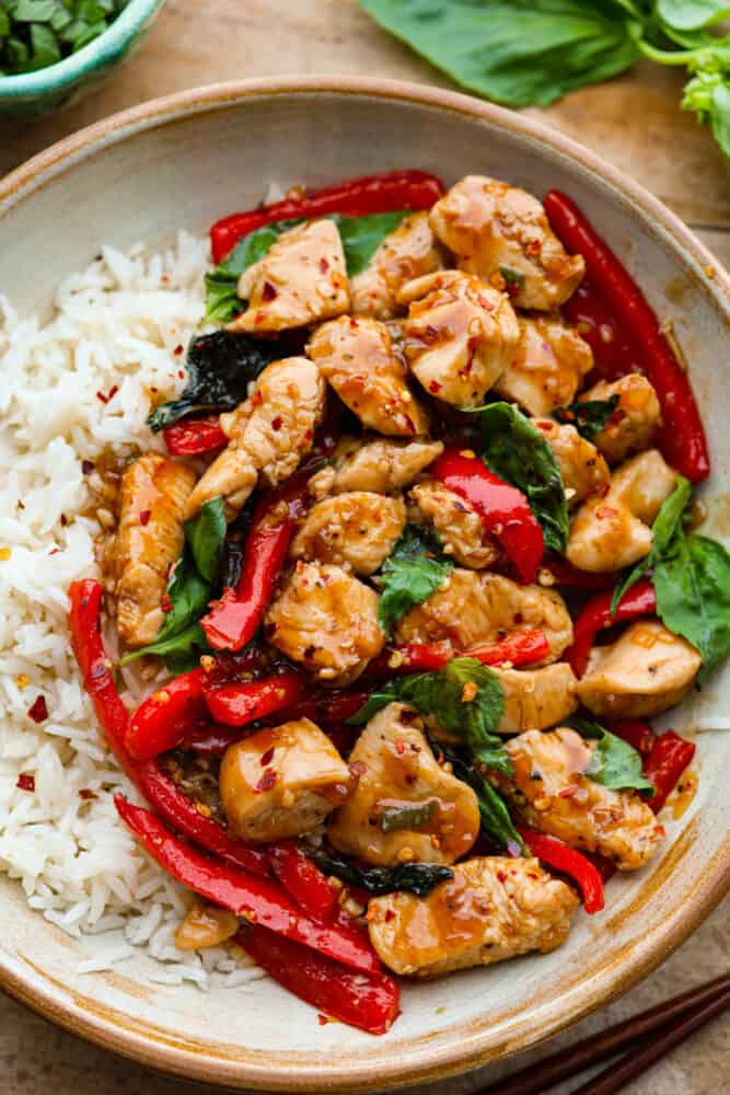 Thai Basil Chicken is a quick and easy chicken dinner that is bursting with fresh flavors. Bell peppers, fresh basil, and a unique blend of sauces make this chicken so crave-able! A close up of Thai basil chicken.