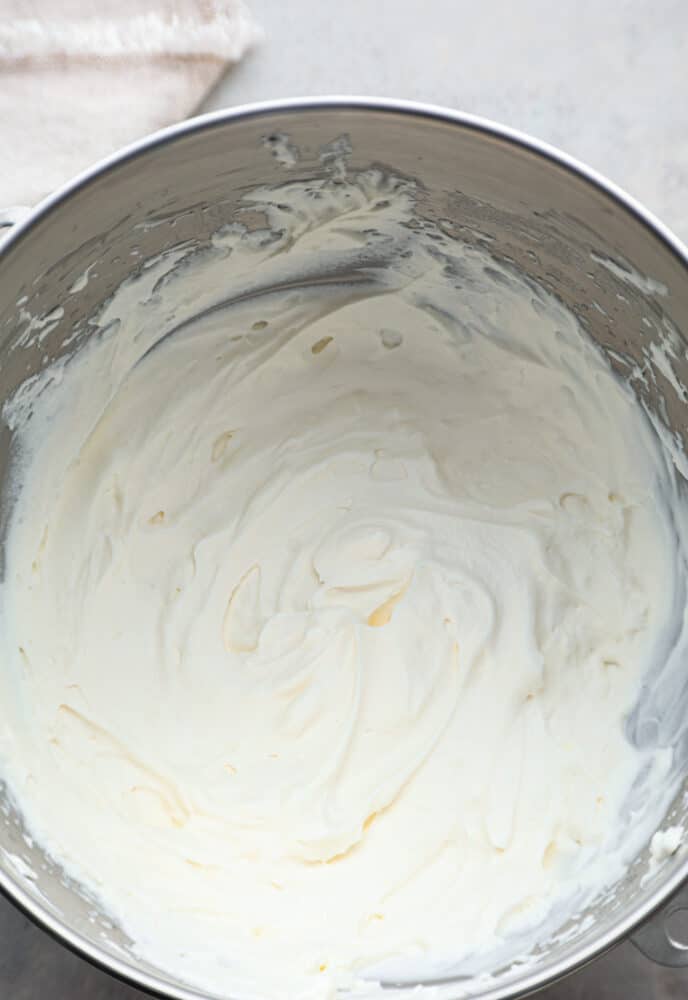 Stop running to the store for Cool Whip, this homemade Whipped Cream is so much better! It's real fresh cream without added preservatives or flavors, and it makes the perfect topping for your cakes, cobblers, and sundaes. A look into the mixer bowl with the whipped cream.