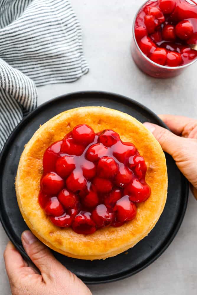 Get ready to indulge in the tastiest and easiest cheesecake you'll ever make! My air fryer never fails to impress- this amazing dessert is another great recipe to add to the list! When you're craving something sweet, air fryer cheesecake requires minimal effort and time, and is a great way to impress your guests or treat yourself to something special. Top-down view of a whole cheesecake topped with fruit.