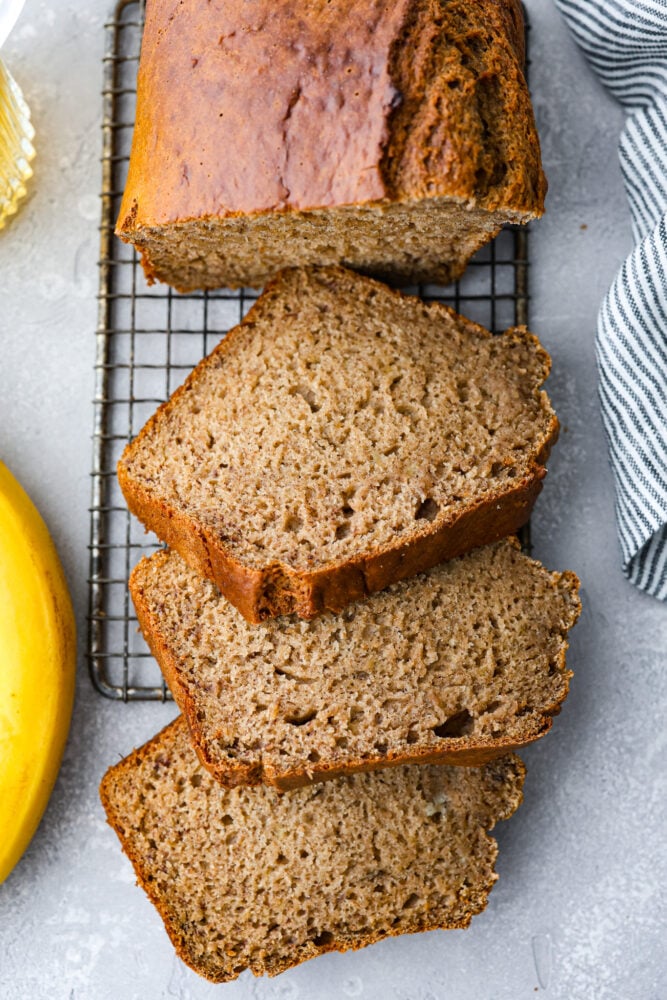 Have you ever tried adding some bubbly goodness to your favorite fruit bread? Well, if you haven't, you're missing out on an amazing treat! This banana beer bread is moist, slightly sweet, with a subtle beer taste that adds a fun twist to the classic banana bread recipe, and the best part? It's super easy to make! Banana beer bread cut into 3 slices.