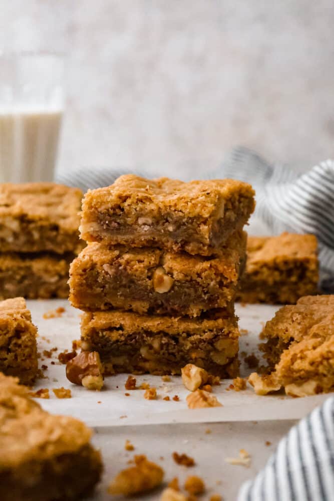 These chewy brown butter blondies are enhanced with the rich flavor of browned butter and loaded with (optional) nuts and candy pieces. Don't worry if you've never browned butter before, it's easy and I'll walk you through the steps below! Brown butter blondies stacked on top of each other on a plate.