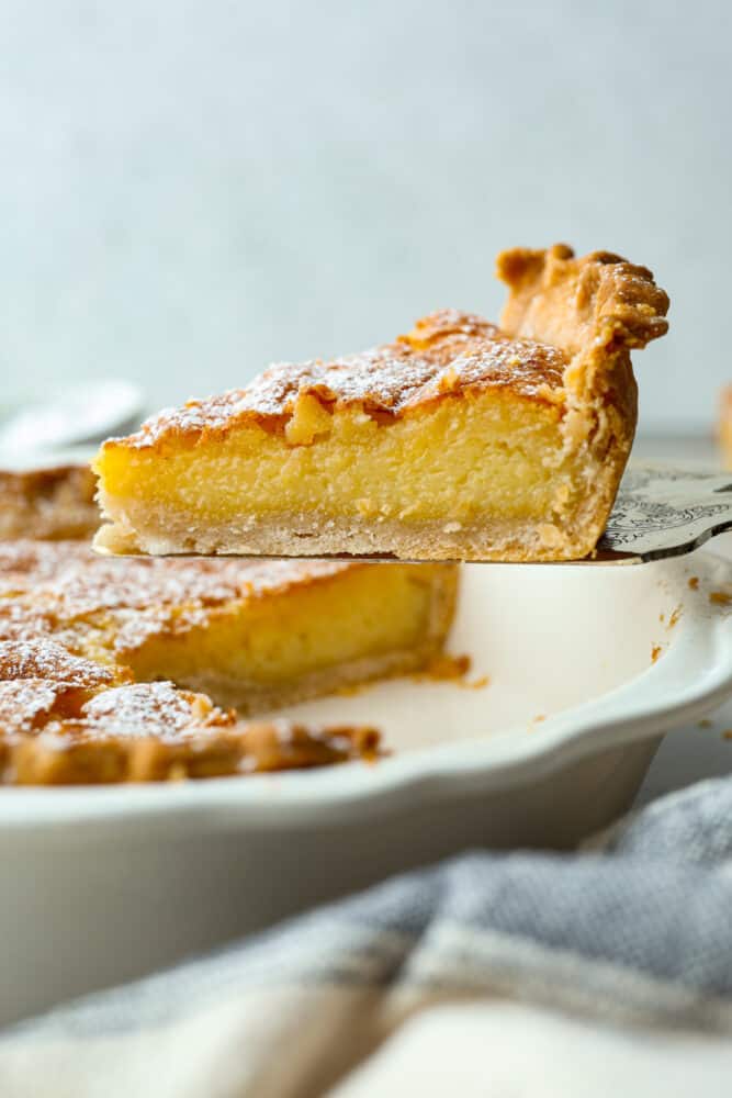 This classic Southern dessert is a delicious combination of sweet, tangy, and buttery flavors all wrapped up in a flaky crust. Its custard-like filling has a smooth and creamy texture that will have you hooked. And the best part? Chess pie is super easy to make and only takes 10 minutes of prep! A slice of pie being served with a cake spatula.