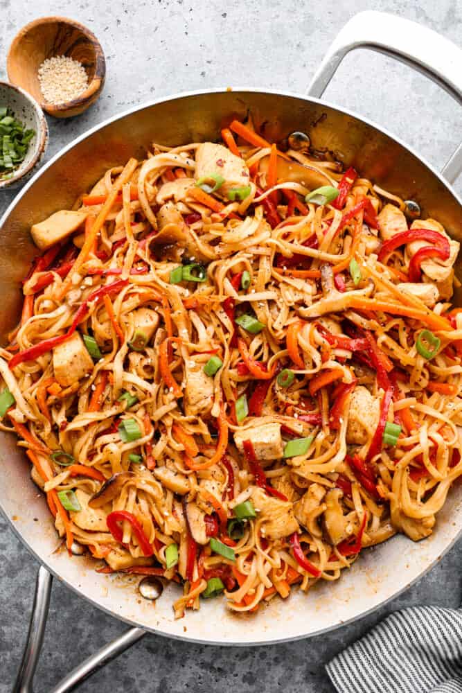 Homemade Chicken Lo Mein is a classic Chinese noodle dish that tastes so much better than takeout! Noodles drenched in a delicious savory sauce paired with perfectly cooked chicken and tender peppers and carrots makes for a yummy and satisfying meal. Chicken lo mein in the frying pan.
