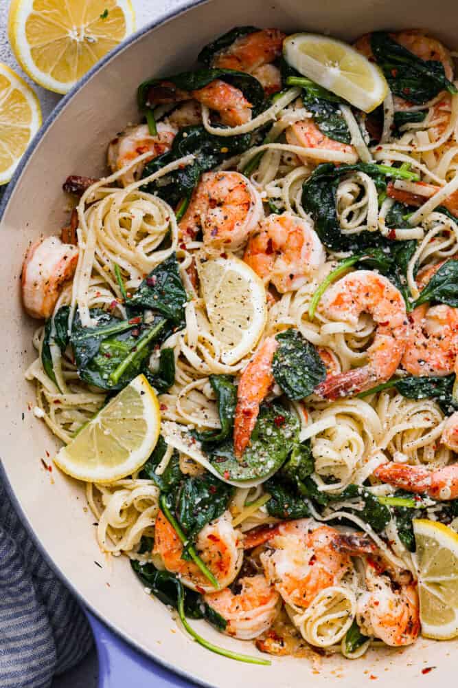 Lemon Garlic Parmesan Shrimp Pasta is made in just one pot and ready in 30 minutes! Fresh shrimp is cooked in a buttery lemon garlic sauce and tossed in fresh parmesan cheese and pasta. It's unbelievably good and sure to become a new favorite! A close up on lemon garlic parmesan shrimp pasta in the pan.