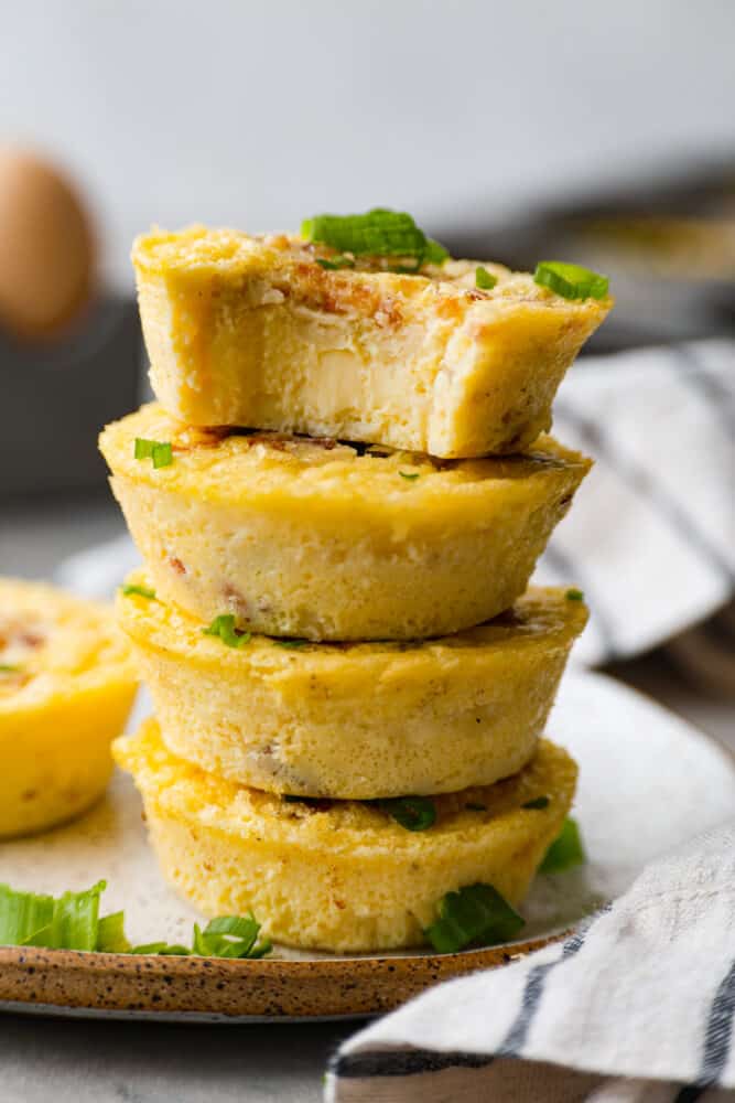 Iโve been hooked on Starbucks egg bites for years, but not the price! This homemade version is just as fluffy and flavorful, and makes the perfect grab-and-go, protein-packed breakfast. Starbucks egg bites stacked on top of each other with a bite taken out of the top one.