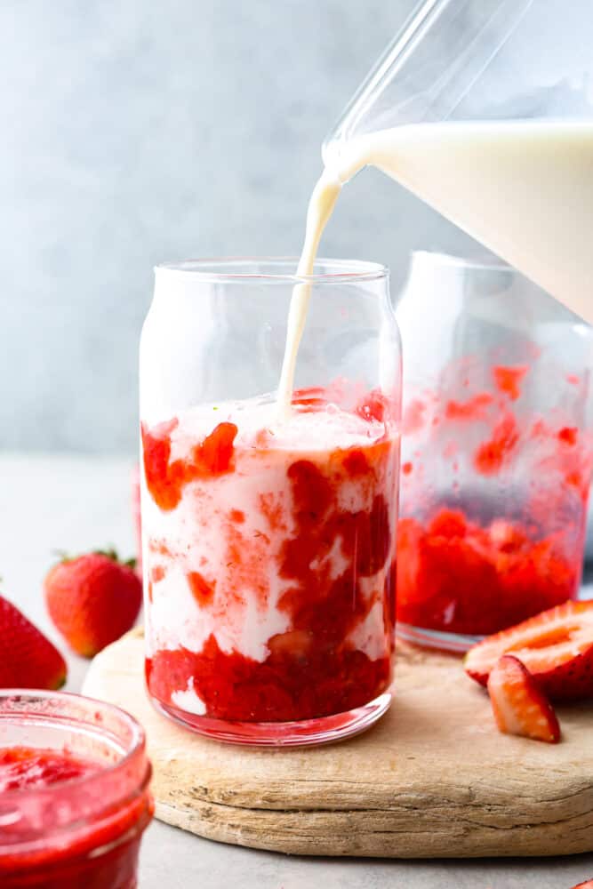 Homemade Korean strawberry milk is a sweet and fruity treat that is sure to satisfy your taste buds. The blend of fresh strawberries and creamy milk creates a perfectly balanced flavor that is both indulgent and refreshing. Sipping on a glass of this cute and tasty beverage brings the café culture of Seoul straight to your kitchen! Milk being poured into a glass.