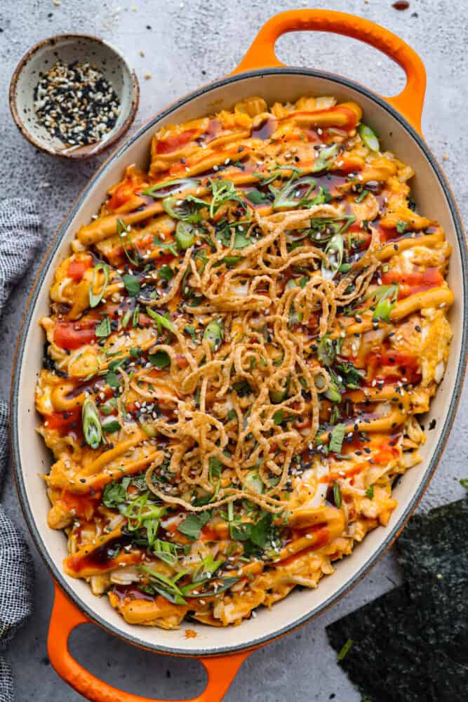 My simple Sushi Bake has all the flavors you love about sushi in an easy, no-roll casserole-style dish. Itโs faster, more affordable, and perfect for feeding a crowd without sacrificing that sushi fix. Sushi bake in an orange casserole dish with sesame seeds off to the side.