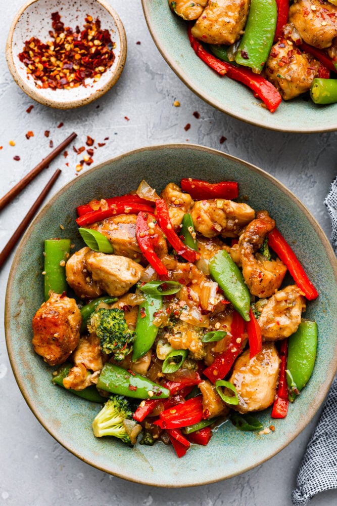 Szechuan chicken is all about bold flavors, with the perfect balance of heat, sweetness, and tanginess. And the best part? It's way better than the takeout version! Let's fire up those taste buds and get cooking! Top-down view of Szechuan chicken served in a blue-green bowl.