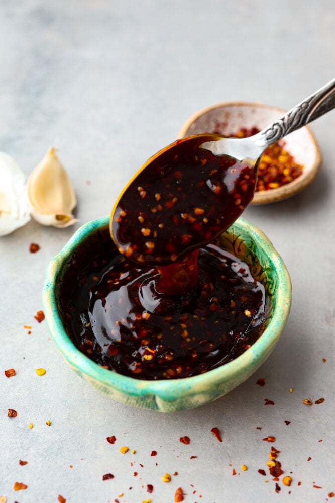 Once you taste homemade Szechuan sauce, you'll be wondering how you ever survived without it. It's so easy to mix up and doubles as both a dip and a marinade! It will take all of your Chinese-inspired dishes to the next level and have your family licking their plates. Dipping a spoon into a bowl of Szechuan sauce.