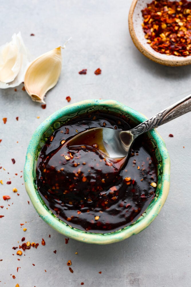 Once you taste homemade Szechuan sauce, you'll be wondering how you ever survived without it. It's so easy to mix up and doubles as both a dip and a marinade! It will take all of your Chinese-inspired dishes to the next level and have your family licking their plates. Hero image of Szechuan sauce in a small blue-green bowl.